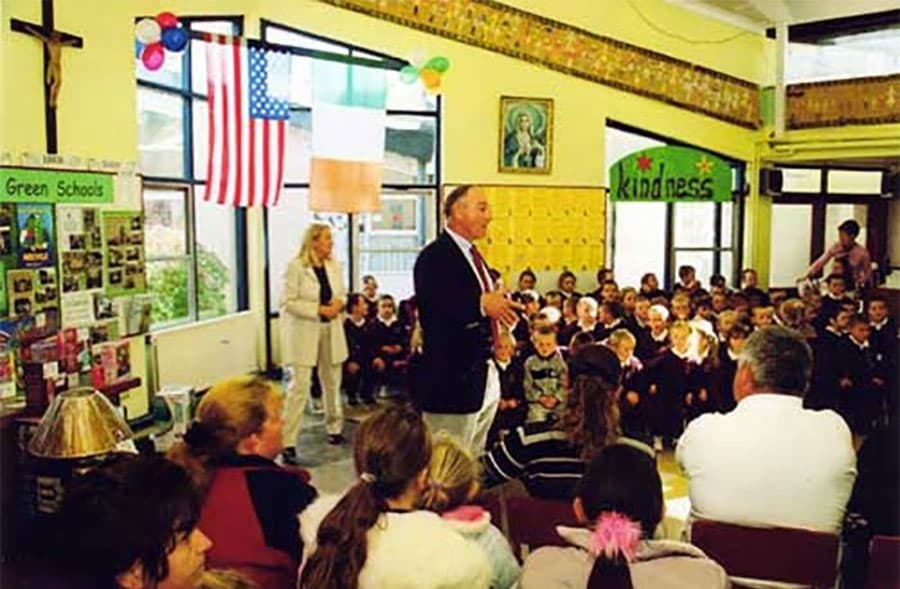 Billy Higgins speaking to children in Ireland with US and Irish flags
